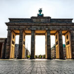 Frontale Ansicht des Brandenburger Tors in Berlin bei Sonnenlicht und leerem Platz.