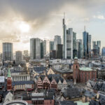 Blick über die Altstadt von Frankfurt auf die moderne Skyline im Licht der untergehenden Sonne.