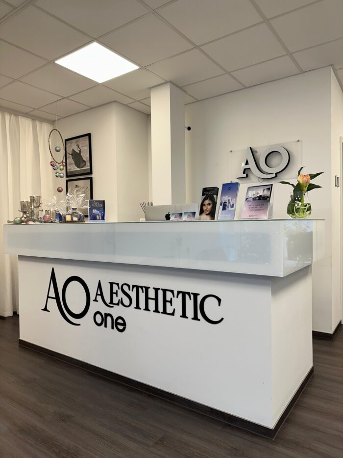 Moderner Empfangsbereich von Aesthetic One in Dortmund mit weißem Tresen und dekorativen Elementen