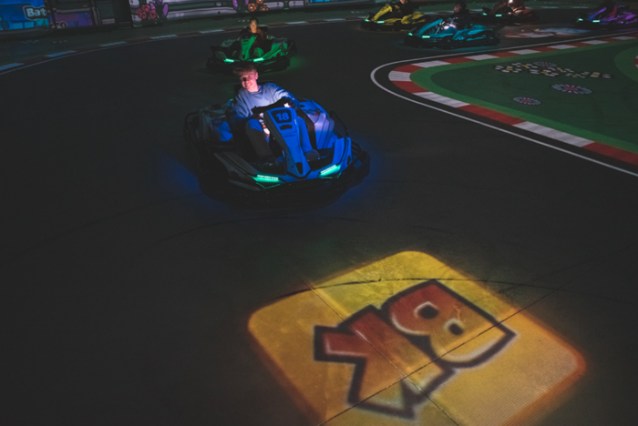 Battlekart-Fahrer auf digital projizierter Strecke mit Logo-Elementen in Dissen