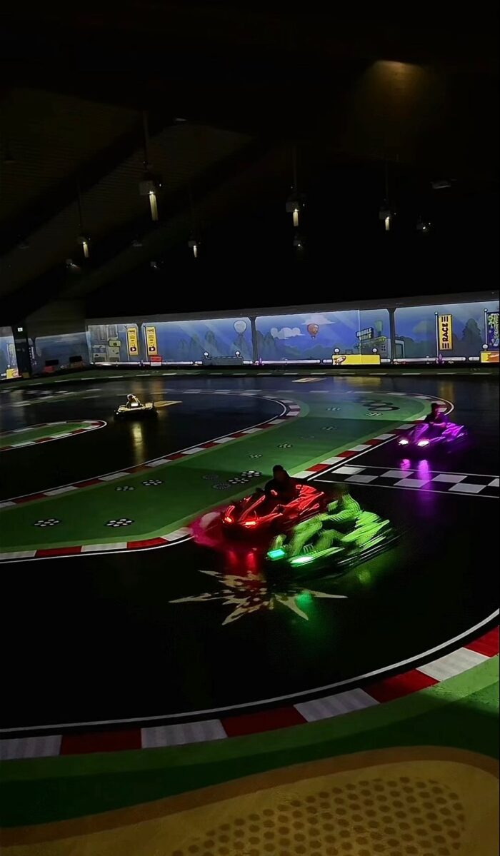 Battlekart-Fahrzeuge mit Lichteffekten auf digital projizierter Rennstrecke in Dissen