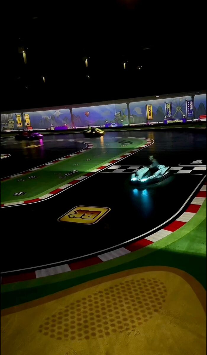 Battlekart-Fahrzeuge mit Lichteffekten auf kurviger Strecke bei Battlekart Dissen