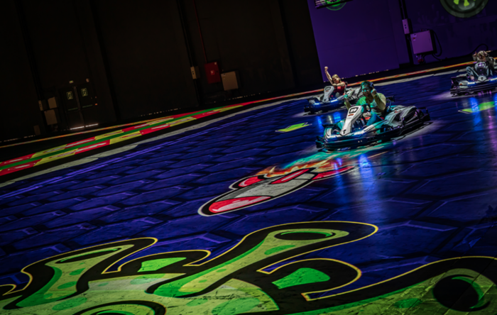 Battlekart-Fahrer auf bunter Spielstrecke mit Projektionen in Dissen