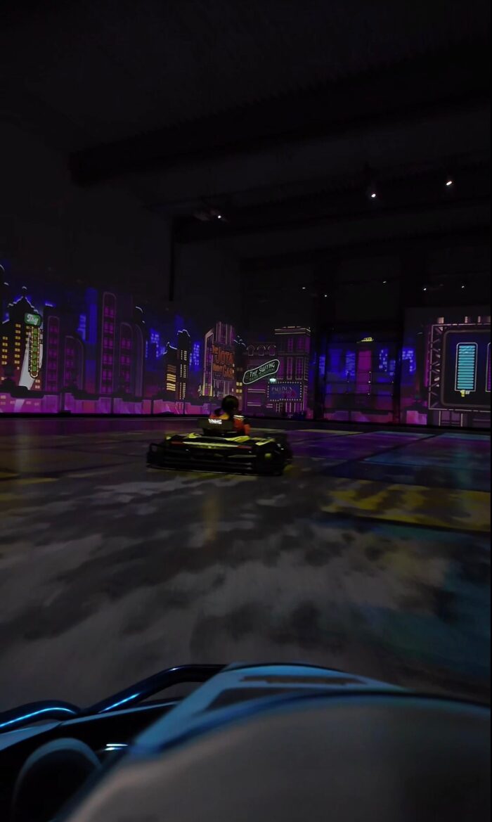 Battlekart-Fahrzeug auf projizierter Stadtstrecke mit Neonlichtern bei Battlekart Dissen