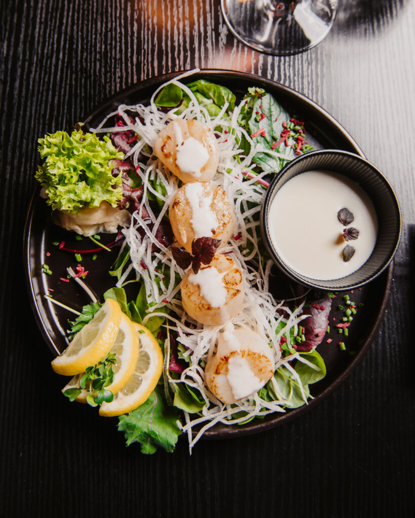 Fein angerichtete Vorspeise mit Jakobsmuscheln und Salat im DEN Restaurant Düsseldorf