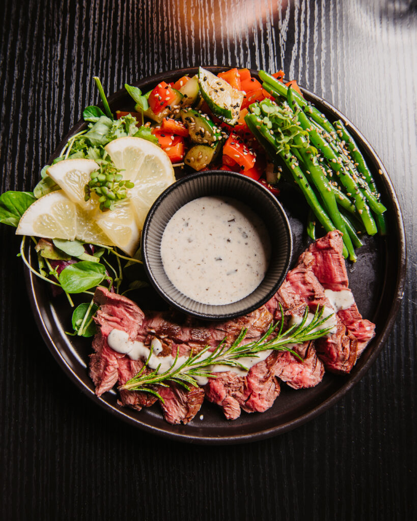 Medium gebratenes Steak mit Gemüse und Dip im DEN Restaurant Düsseldorf