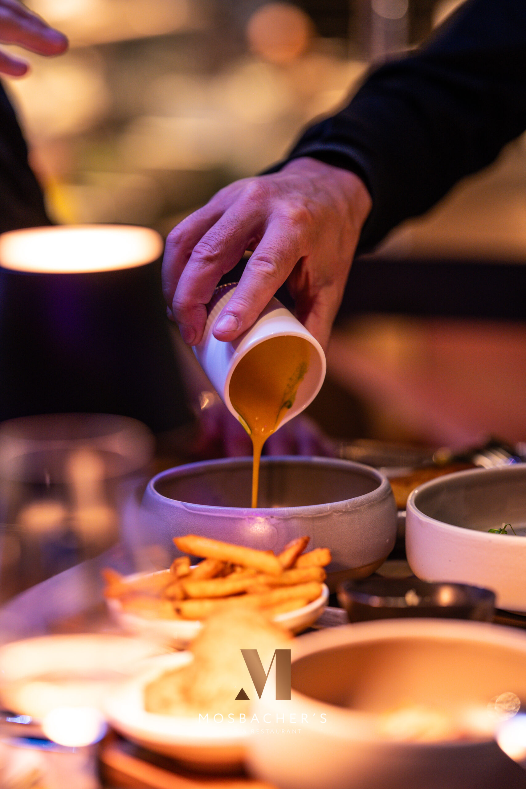 Cremige Sauce wird elegant in eine Schale neben Pommes im Mosbacher’s Gelsenkirchen gegossen