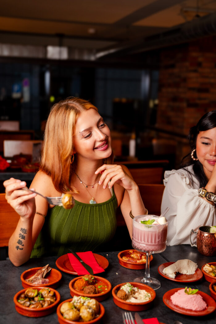 Zwei Frauen genießen Tapas und Drinks bei stimmungsvoller Atmosphäre im Tapas & More Dortmund