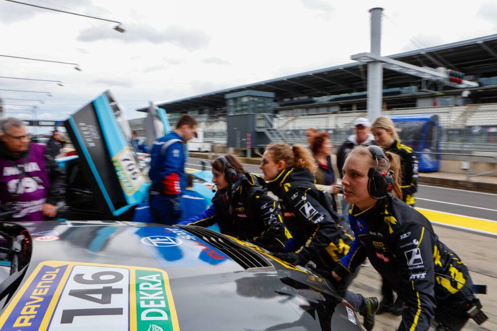 Frauen-Boxenteam von WS Racing bewegt Rennfahrzeug in der Boxengasse