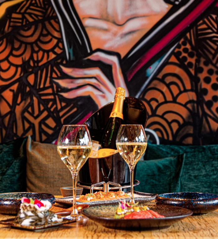 Eleganter Tisch mit Champagner und kunstvoller Wandbemalung im Zweigleisig Düsseldorf