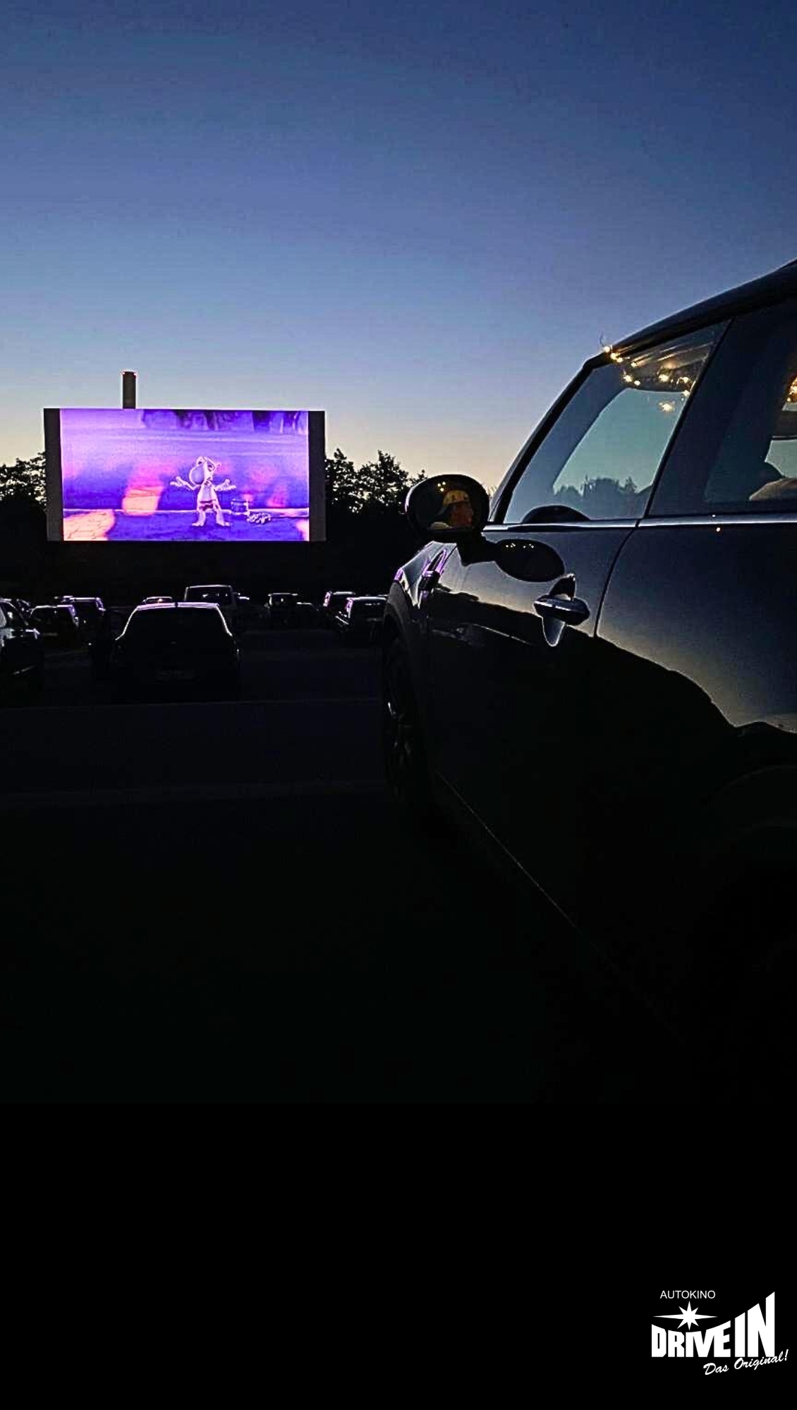 Abendstimmung im Autokino Essen mit laufendem Film und parkenden Autos