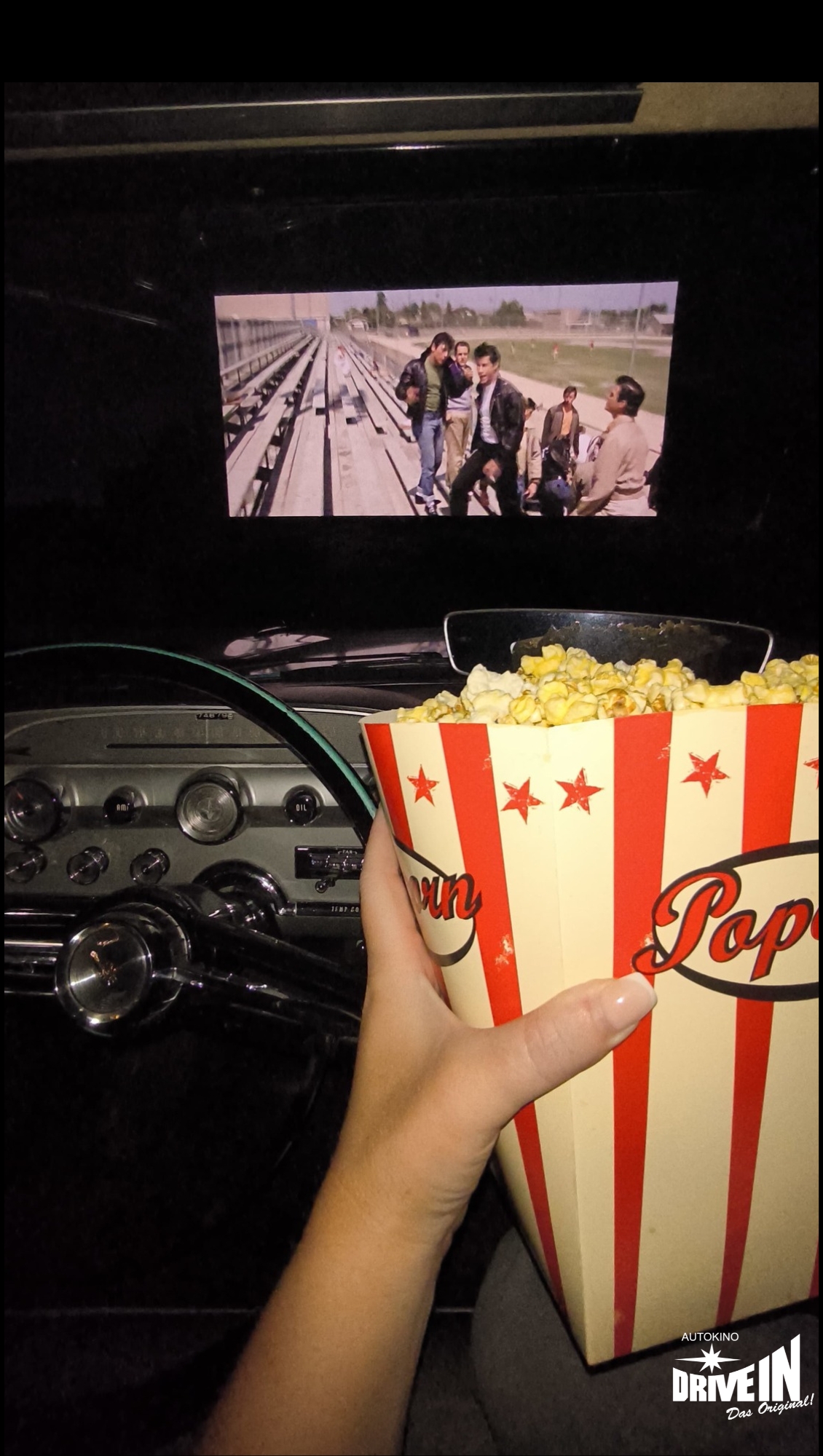 Popcornbox im klassischen Auto mit Blick auf die Leinwand im Autokino Essen