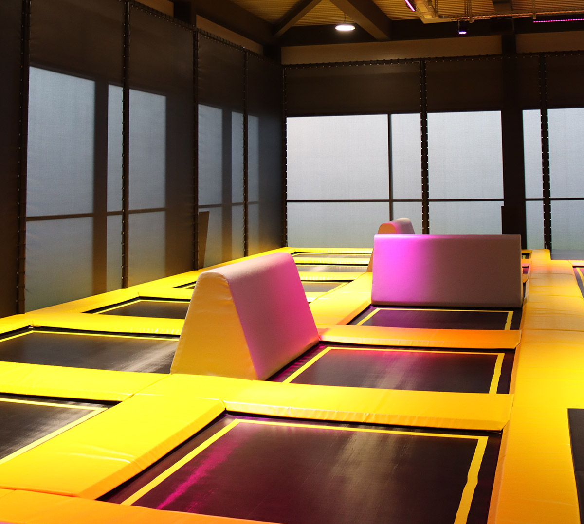 Beleuchtete Trampolinfläche im Cube Funpark Beselich mit farbigen Lichtakzenten und modernen Elementen