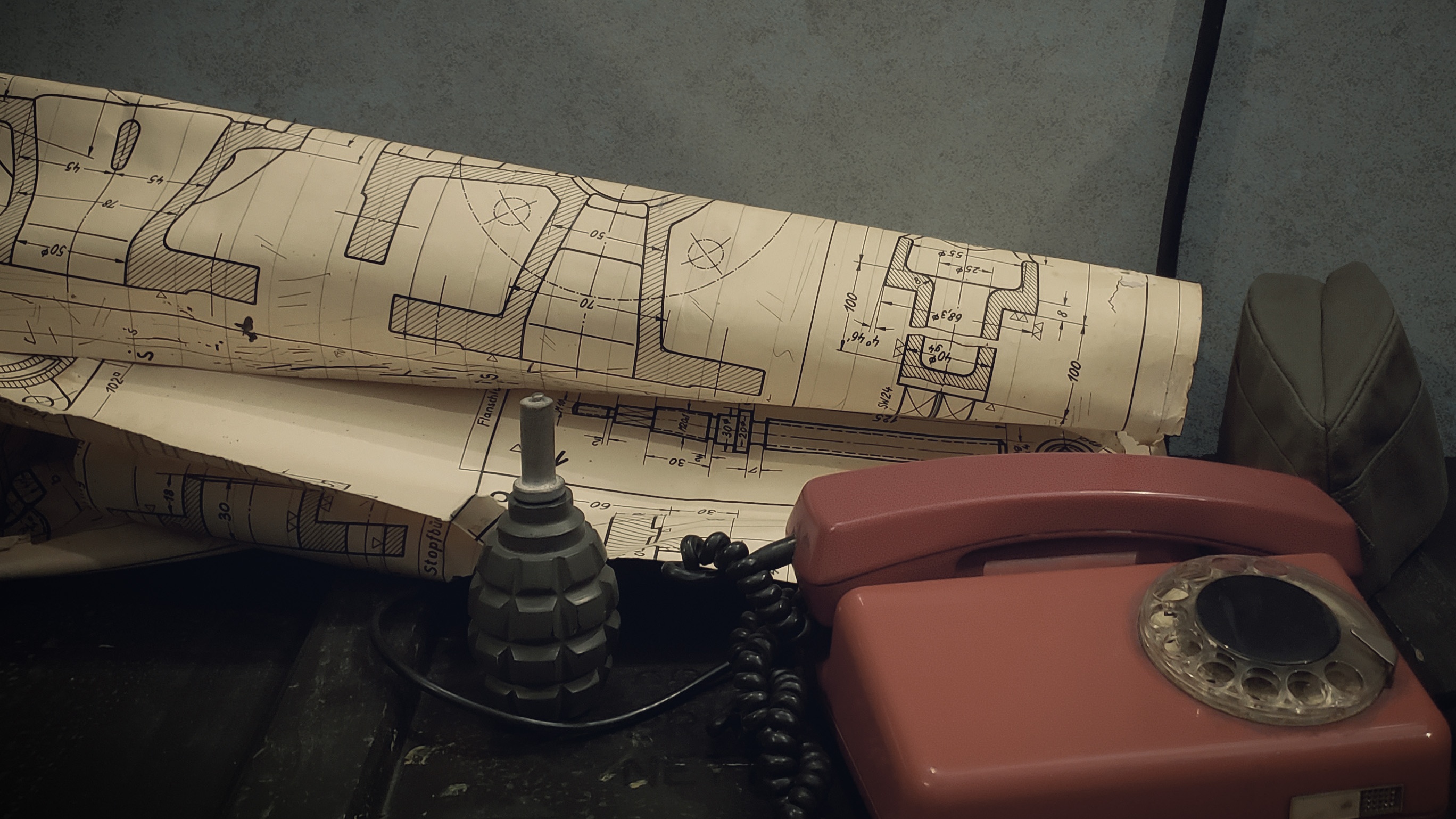 Rotes Wählscheibentelefon, Handgranaten-Requisite und Baupläne im Escape Game „Closed Room“ in Kamen