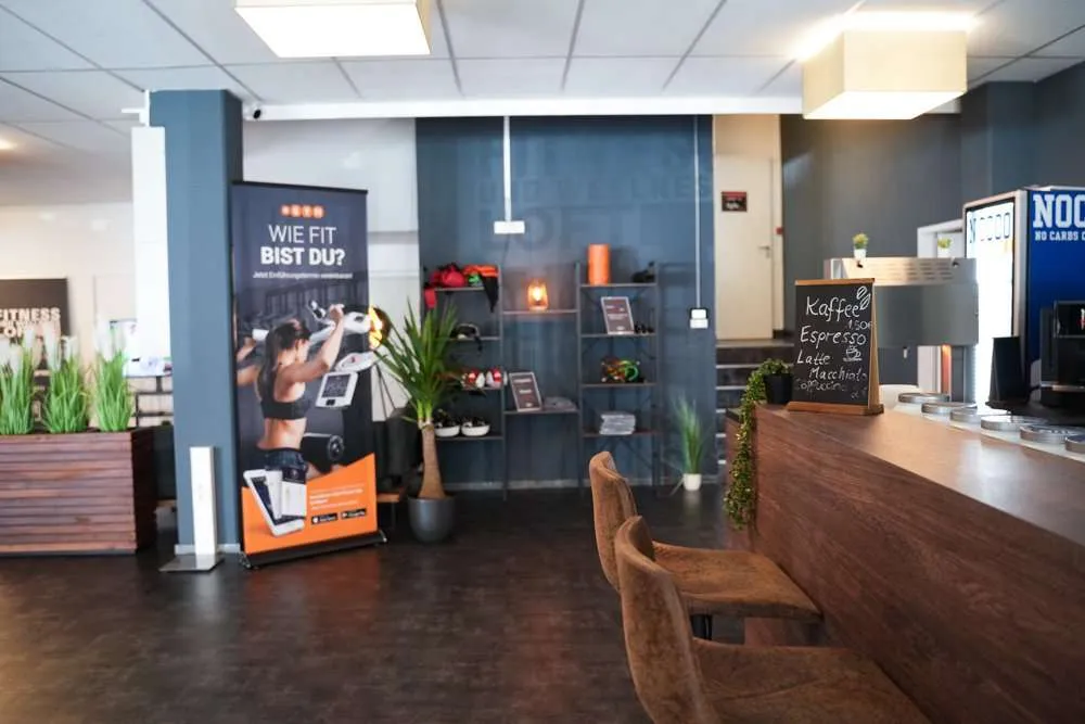 Empfangsbereich mit Tresen, Werbebanner und Deko im Fitness Wellness Loft Schleiden