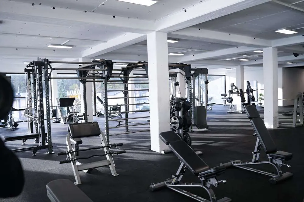 Großzügiger Krafttrainingsbereich mit Hantelbänken und Fitnessstationen im Fitness Wellness Loft Schleiden