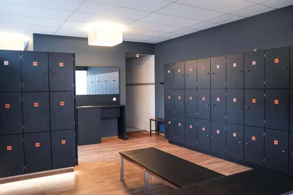 Moderner Umkleidebereich mit Spinden, Sitzbank und Spiegel im Fitness Wellness Loft Schleiden