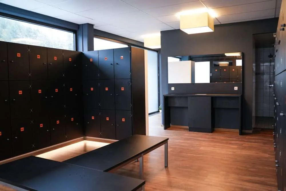 Moderner Umkleideraum mit Spinden, Spiegel und Sitzbank im Fitness Wellness Loft Schleiden