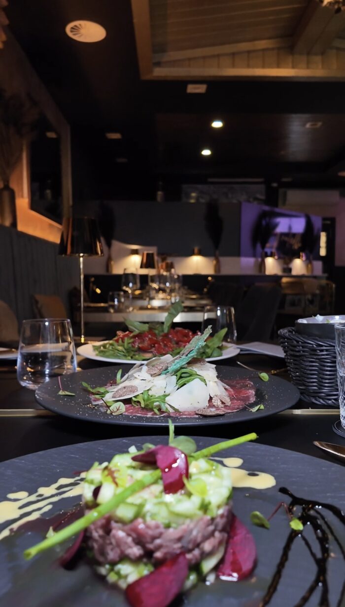 Elegant angerichtete italienische Hauptspeisen auf schwarzen Tellern im stilvollen Ambiente des Ristorante Fratelli Bottrop.