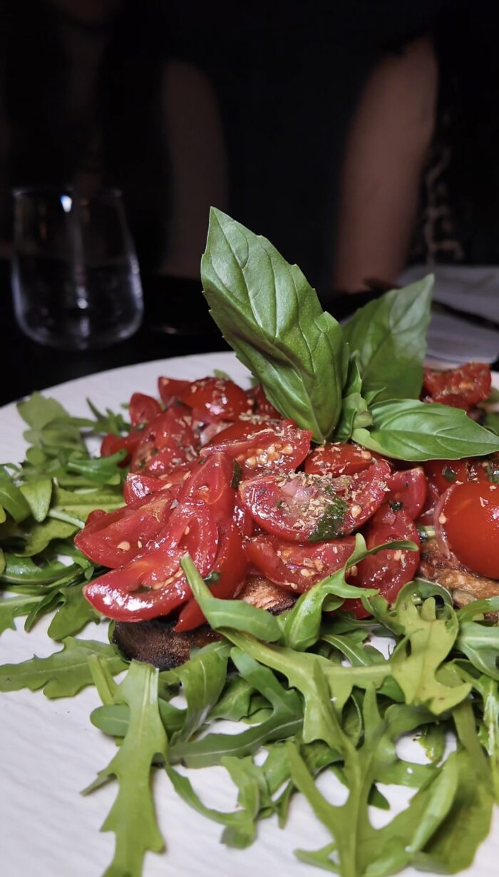 Frischer Tomatensalat mit Rucola und Basilikum, serviert im Ristorante Fratelli Bottrop