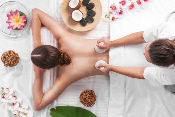Frau genießt eine entspannende Wellnessbehandlung mit Kokosnussprodukten in einem Spa