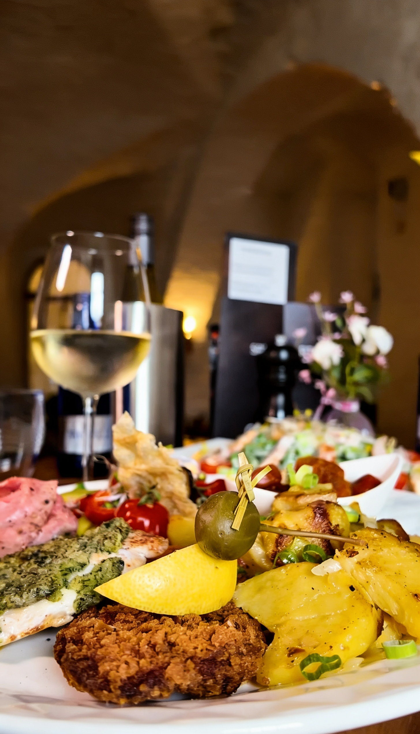 Hauptgericht im Gewölbe Gelsenkirchen – liebevoll angerichtete Speise mit Beilagen und Weißwein in stilvollem Restaurantambiente