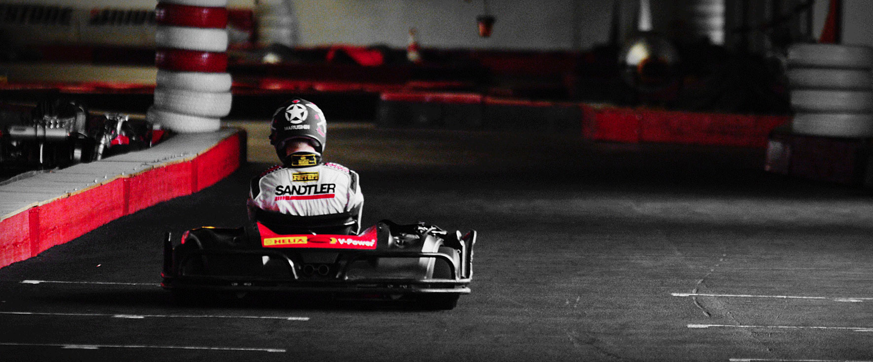 Go-Kart-Fahrer von hinten auf der Indoor-Strecke bei Highway Kart Racing Dortmund