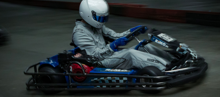 Rennfahrer mit Helm und Overall im Go-Kart bei Highway Kart Racing Dortmund