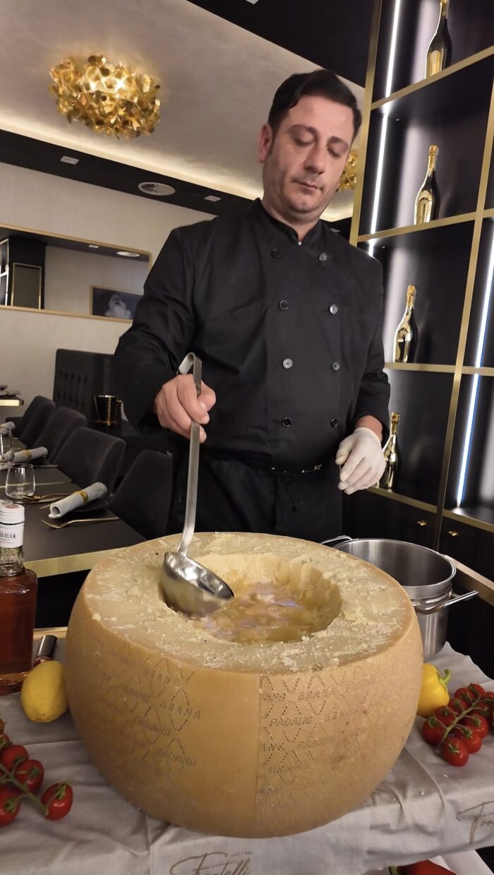 Koch bereitet Pasta im Käselaib im Ristorante Fratelli in Bottrop zu