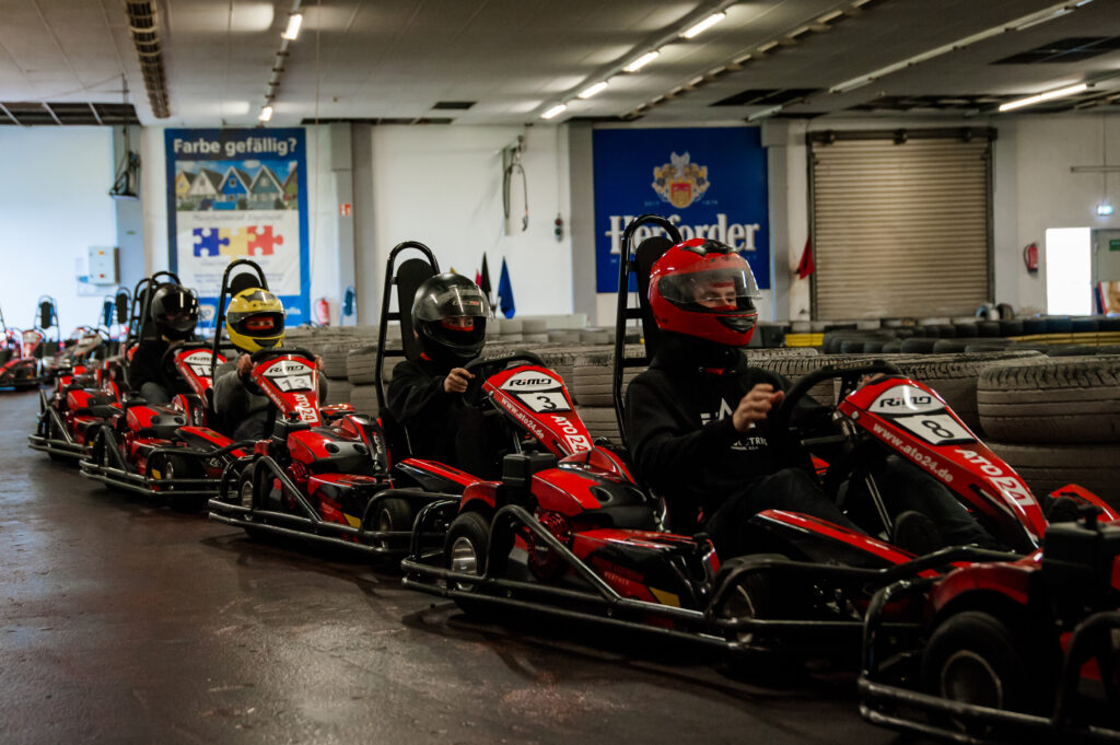 Startaufstellung auf der Kartbahn Werther mit Fahrern in roten Rennkarts