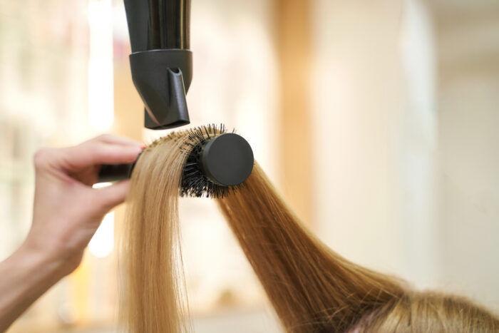Föhnstyling mit Rundbürste als Teil eines Kompletthaarschnitts im Friseursalon