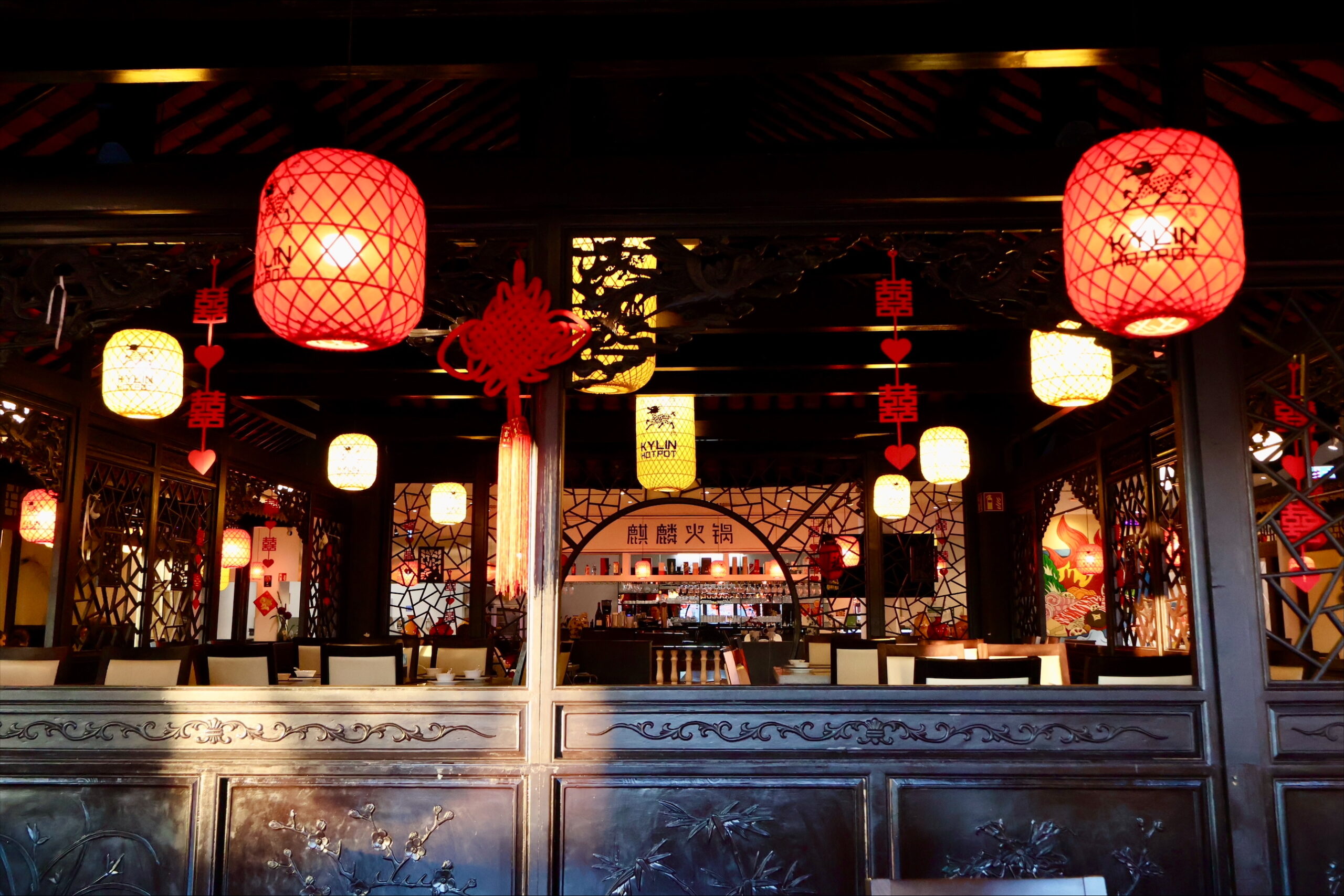 Stimmungsvoll beleuchteter Innenraum des Kylin Hotpot Dreieich mit traditionellen chinesischen Lampions und gemütlichem Sitzbereich