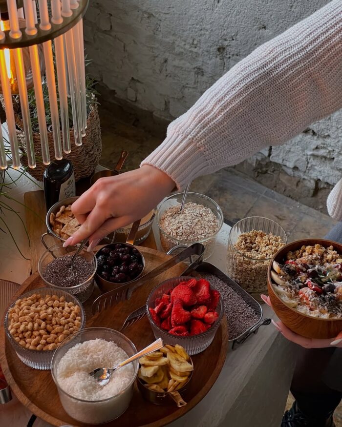 Person stellt sich eine Bowl am Brunchbuffet bei LALA Smashburger Frankfurt zusammen, mit frischen Toppings und Müsli-Auswahl