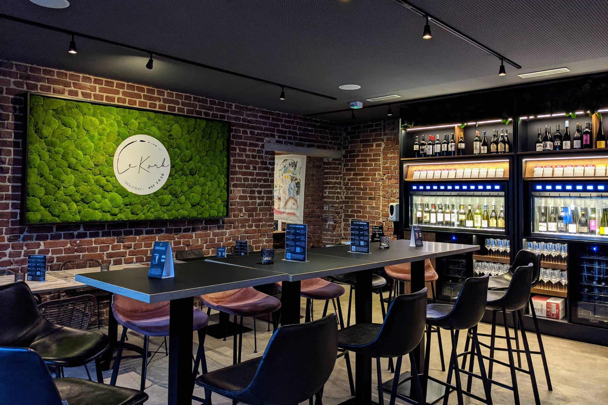 Stilvoll eingerichteter Innenraum der Weinbar Le Kork in Bochum mit Hochtisch und Weinregalen