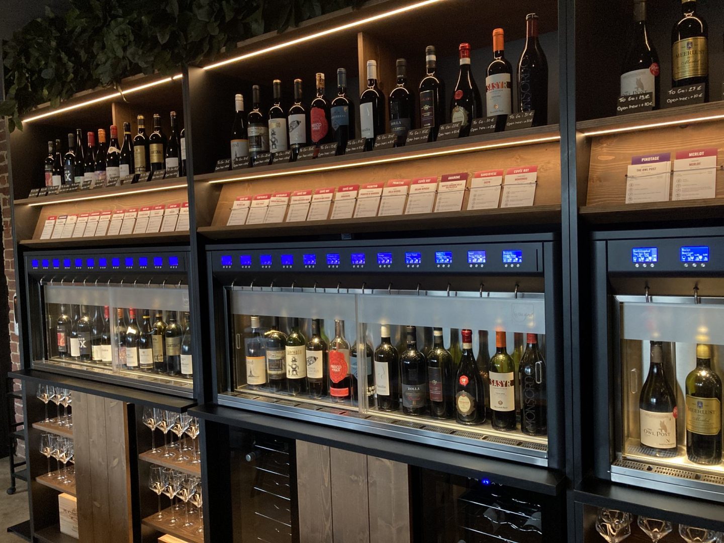 Moderne Weinwand mit verschiedenen Flaschen und Gläsern im Le Kork Bochum