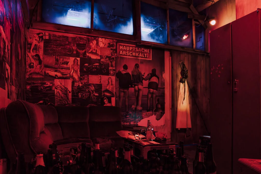 Dunkelrot beleuchteter Raum mit Zeitungsausschnitten und Verhör-Atmosphäre im Rätselraum Ruhrpott Bochum