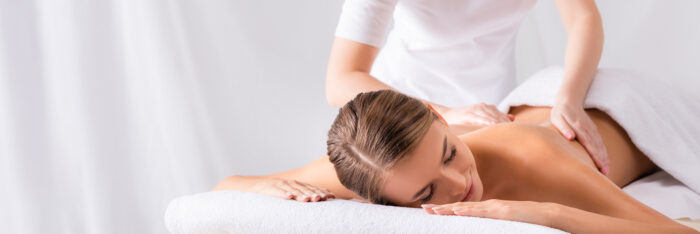 Frau entspannt bei einer klassischen Rückenmassage auf einer Behandlungsliege