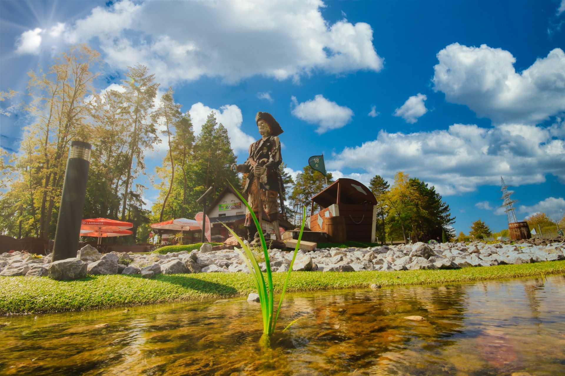 iratenfigur auf einer künstlichen Insel im Wasserbereich des Adventure Golf im Sport- und Freizeitpark Limburg-Linter bei sonnigem Wetter