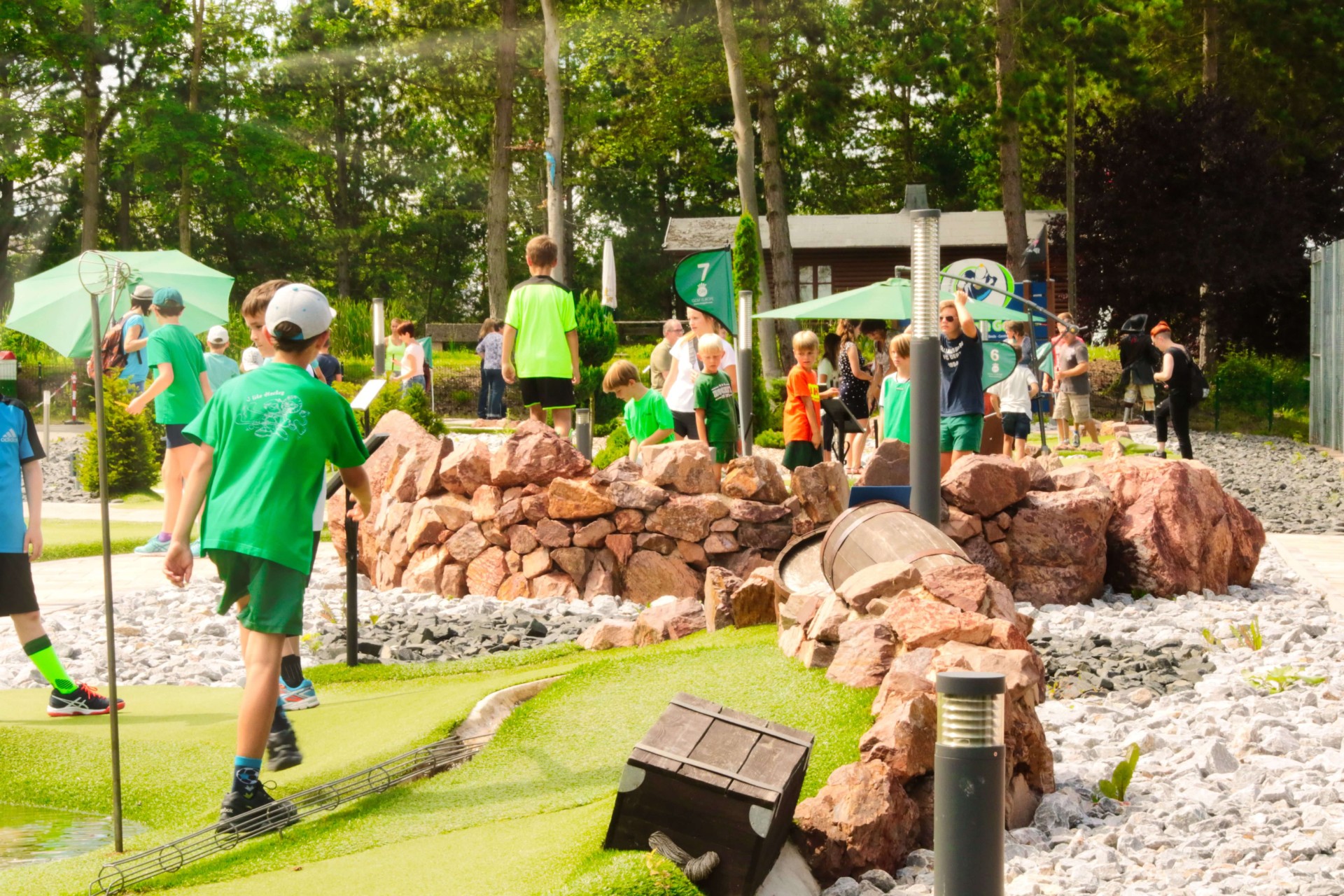 Kindergruppe beim Spielen auf dem Adventure Golf Parcours im Sport- und Freizeitpark Limburg-Linter mit Felsenlandschaft im Hintergrund