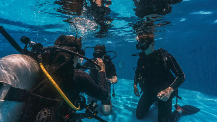 Gruppe von Tauchschülern bei einer Übung unter Wasser im Schnuppertauchkurs des Tauchcenters Wuppertal