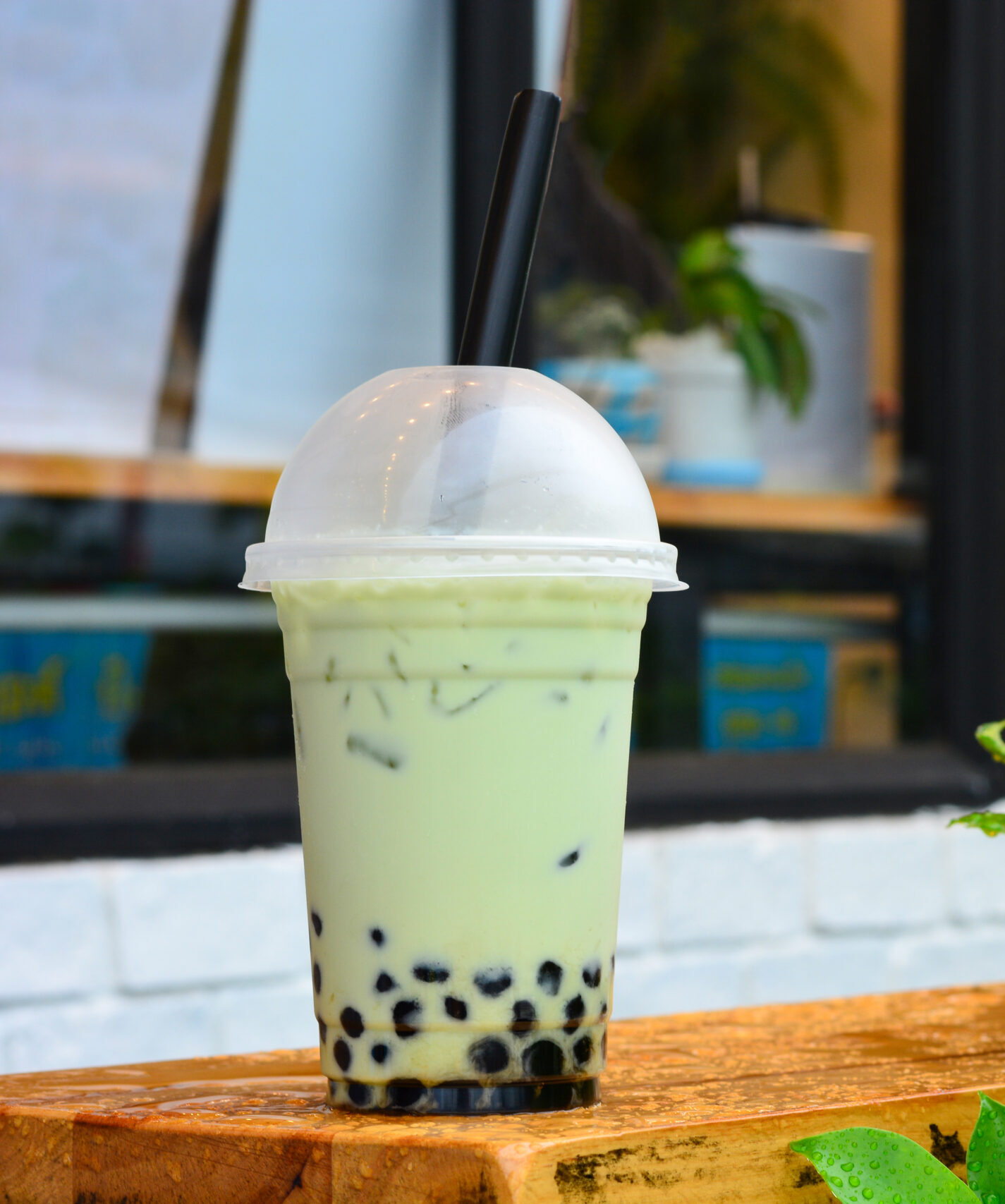 Bubble Tea von Tea99 Frankfurt mit Tapiokaperlen in einem durchsichtigen Becher auf einem Holztisch