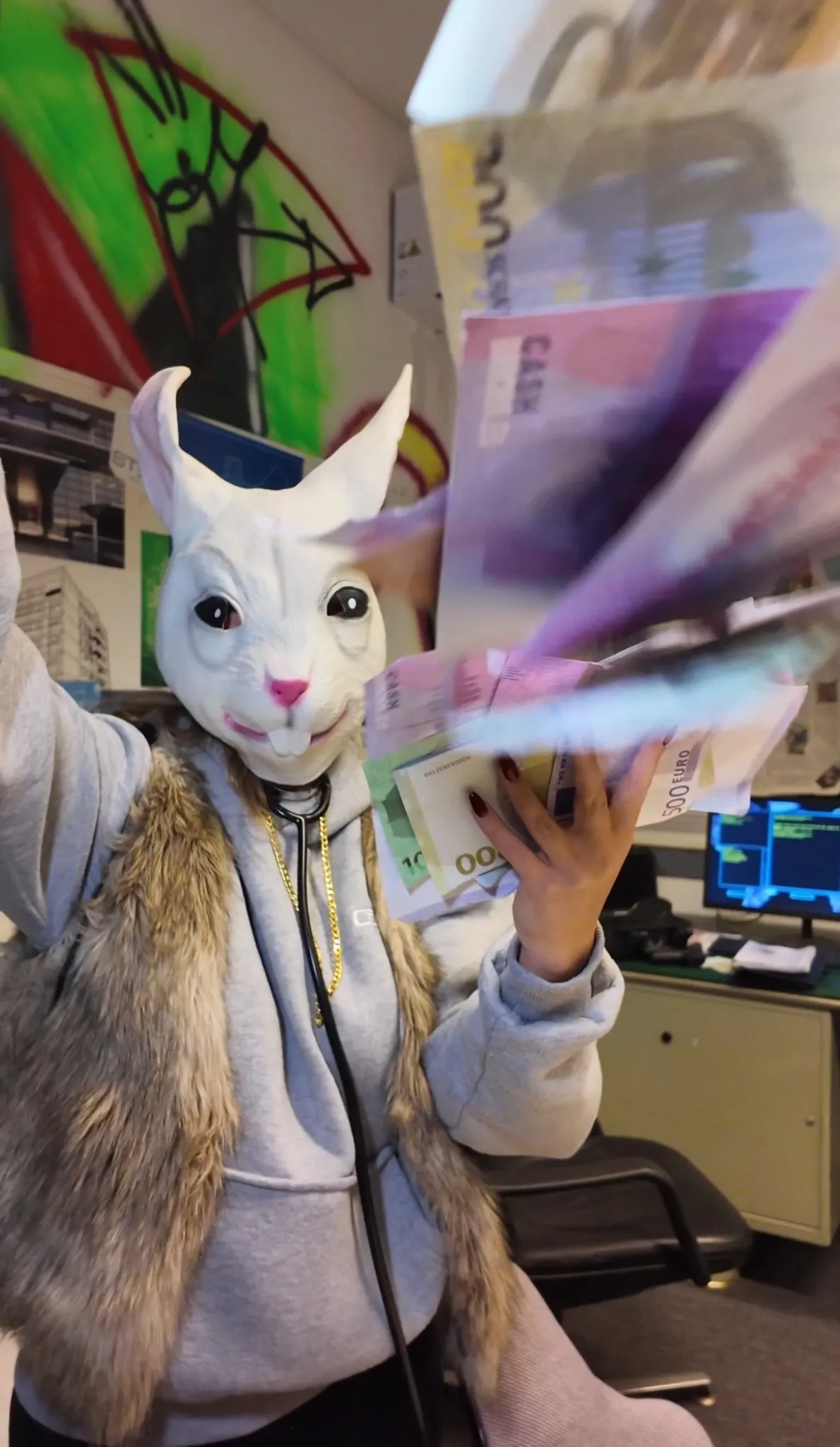 Person mit Hasenmaske wedelt mit Spielgeldscheinen vor der Kamera in einem Raum mit Monitoren und Escape-Game-Atmosphäre – Szene bei Face Off Rüsselsheim
