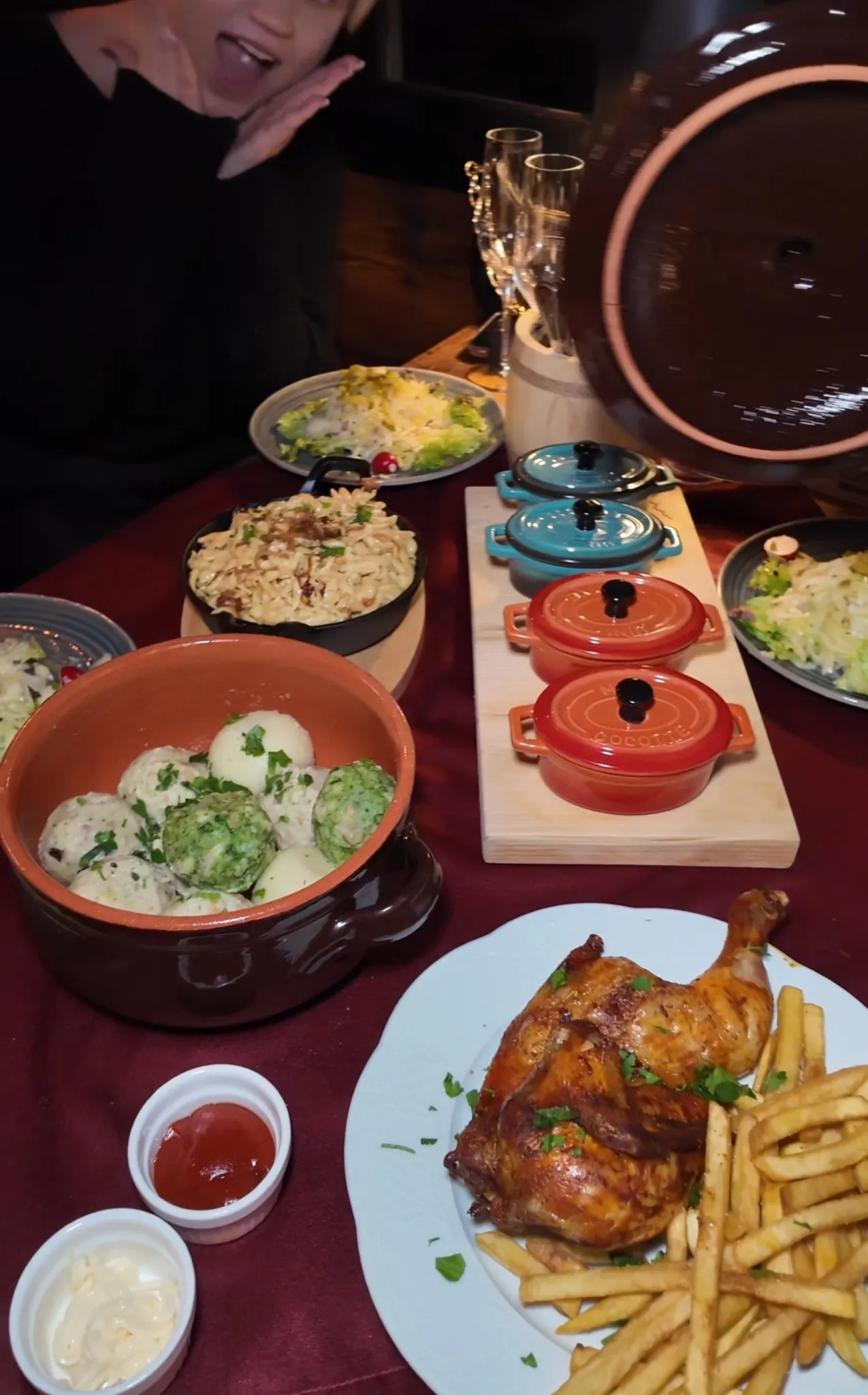 Vielfältiges Buffet beim Knödelfest in der Alm Fernweh mit Knödeln in Sauce, halbem Hendl, Salaten und kleinen Schmorpfännchen auf einem festlich gedeckten Tisch