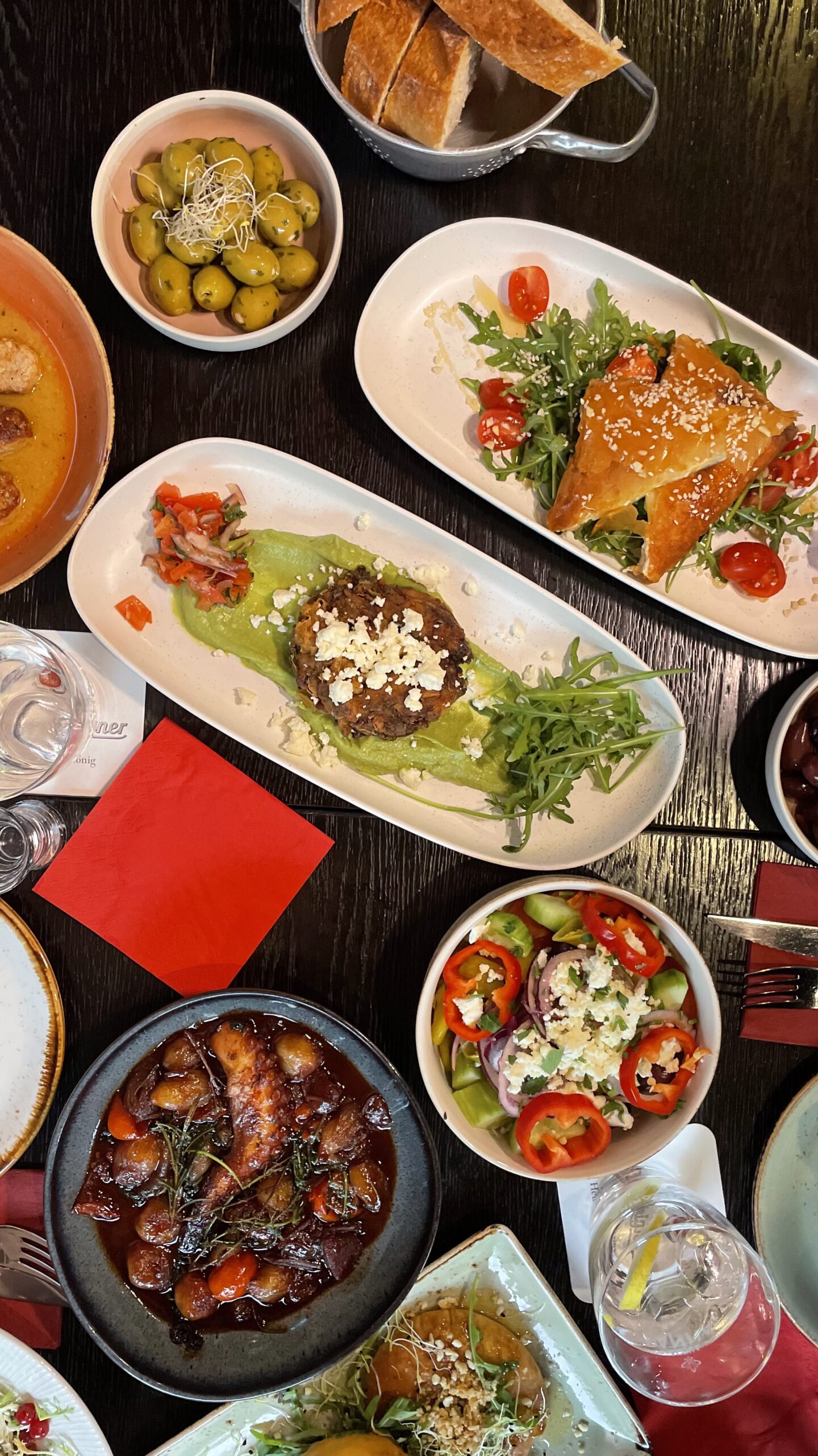 Tisch im Pegasos Oberhausen reich gedeckt mit griechischen Speisen wie Salat, gebackener Käse, Hackfleisch auf Erbsenpüree, Grillgemüse und traditionellen Dips