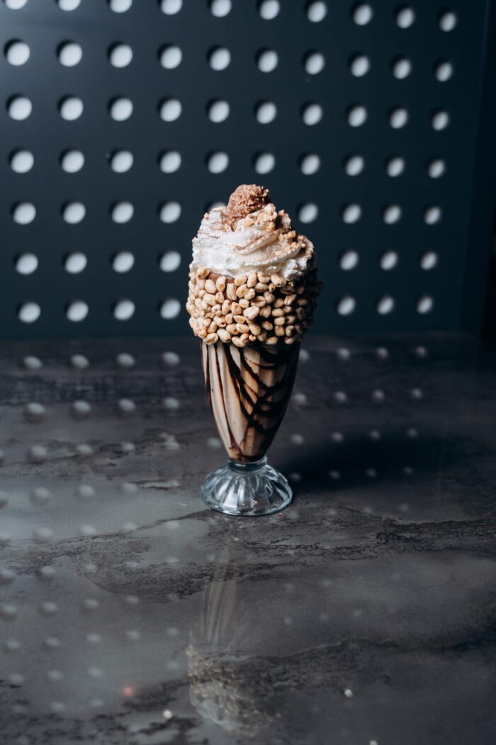 Haselnuss-Schokoladen-Milchshake im hohen Glas mit Sahne, Nussdekor, Schokosauce und gepufftem Crunch am Glasrand – serviert im Shiva Food and More Dinslaken