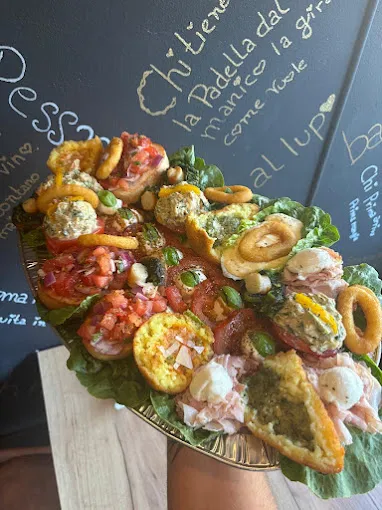 Große italienische Antipasti-Platte aus dem Spaccanapoli Da Enzo Essen mit Bruschetta, gegrilltem Gemüse, Wurst, Käse, Oliven, Taralli und Frischkäsevariationen vor schwarzer Tafelwand