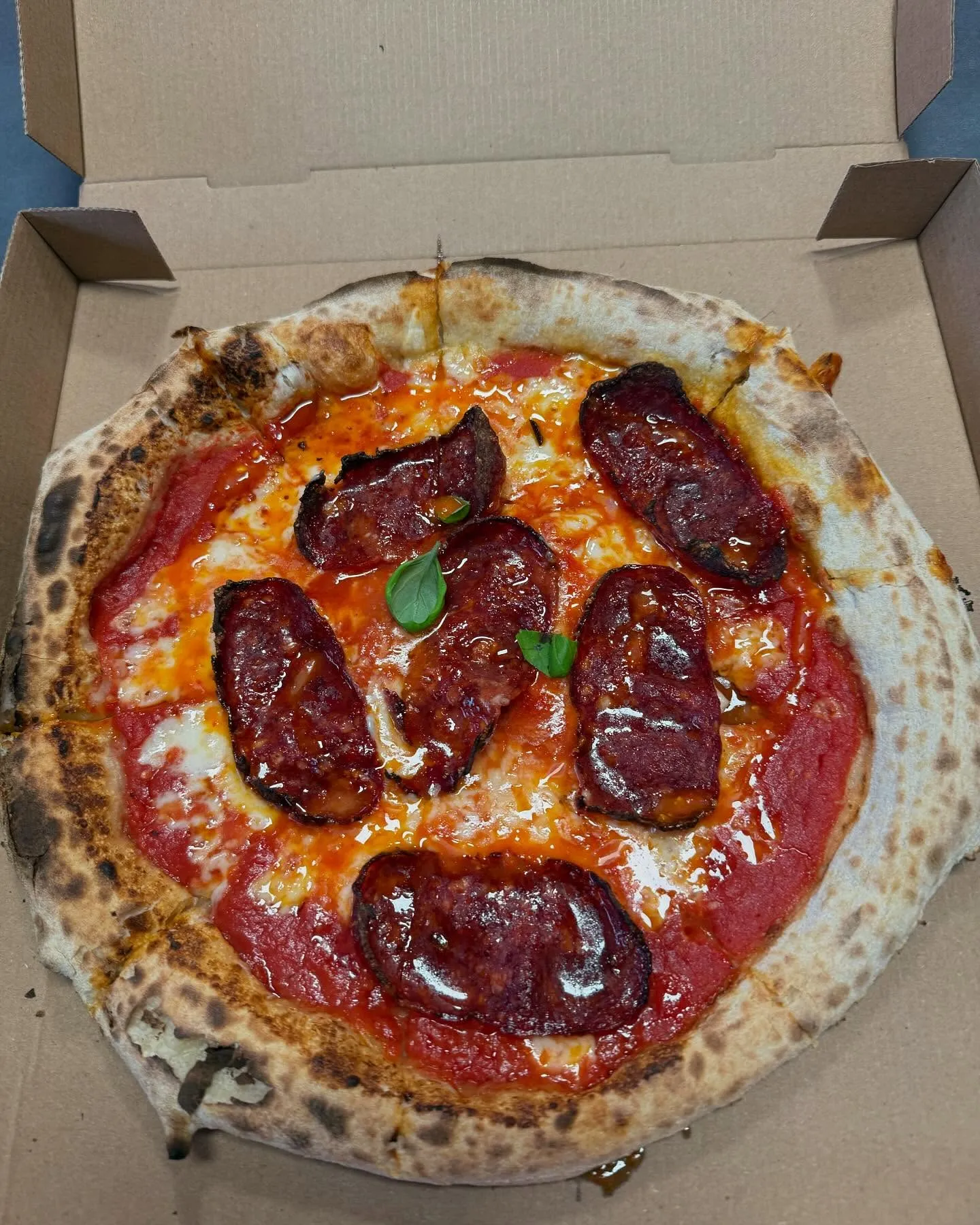 Pizza mit Salami, Tomatensauce und Mozzarella in einer offenen Pizzaschachtel von Tr3minuti Frankfurt