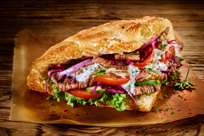 Frisch belegtes Döner-Sandwich mit Salat, Tomaten und Sauce