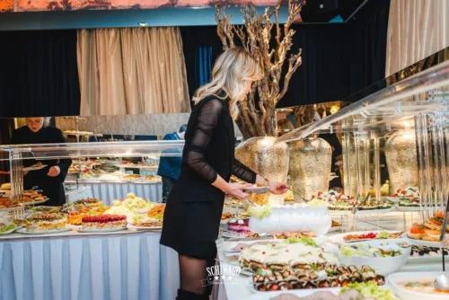 Frau bedient sich am festlich dekorierten Buffet mit Vorspeisen und Desserts im Dr. Schiwago Duisburg