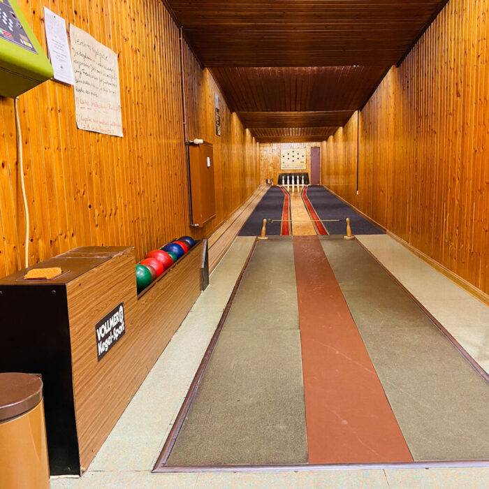 Traditionelle Kegelbahn mit Holzverkleidung und farbigen Kugeln in rustikalem Ambiente